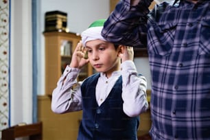 Un homme aidant un jeune garçon à mettre un chapeau