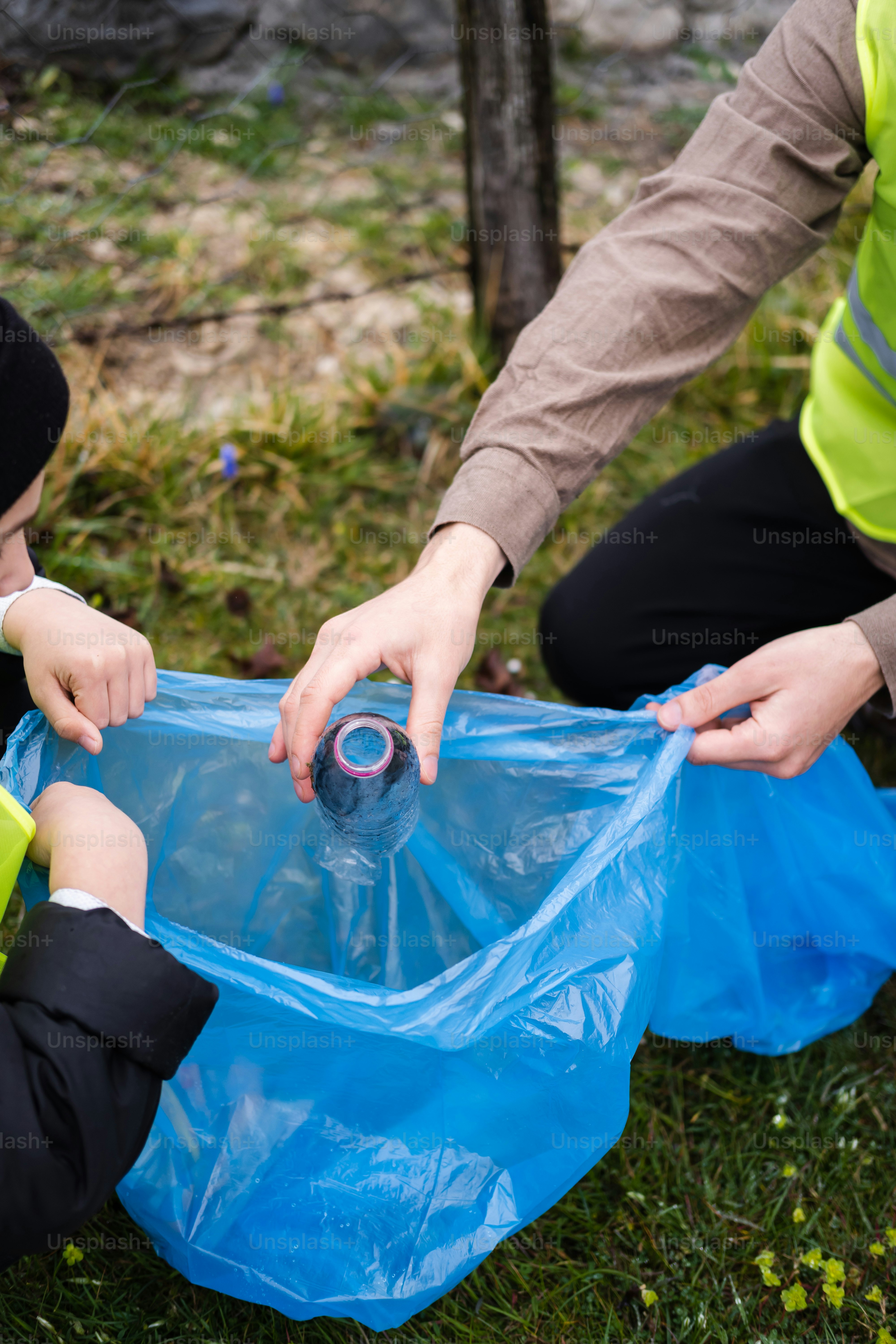 Ein Mann und ein Kind stecken eine Plastikflasche in eine Tüte