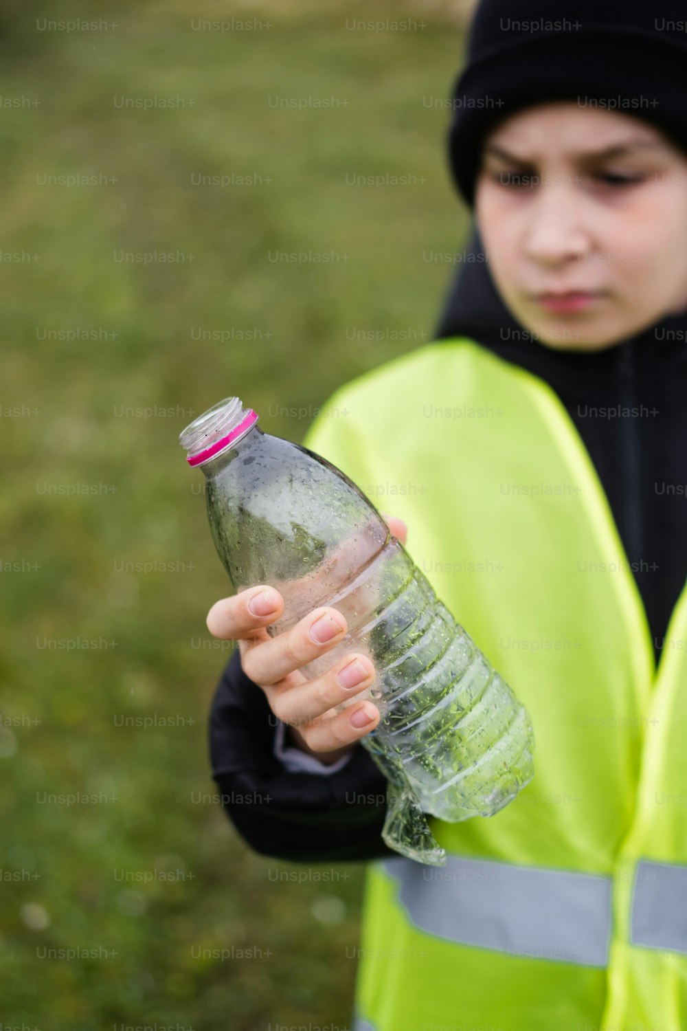 uma pessoa em um colete amarelo segurando uma garrafa de água