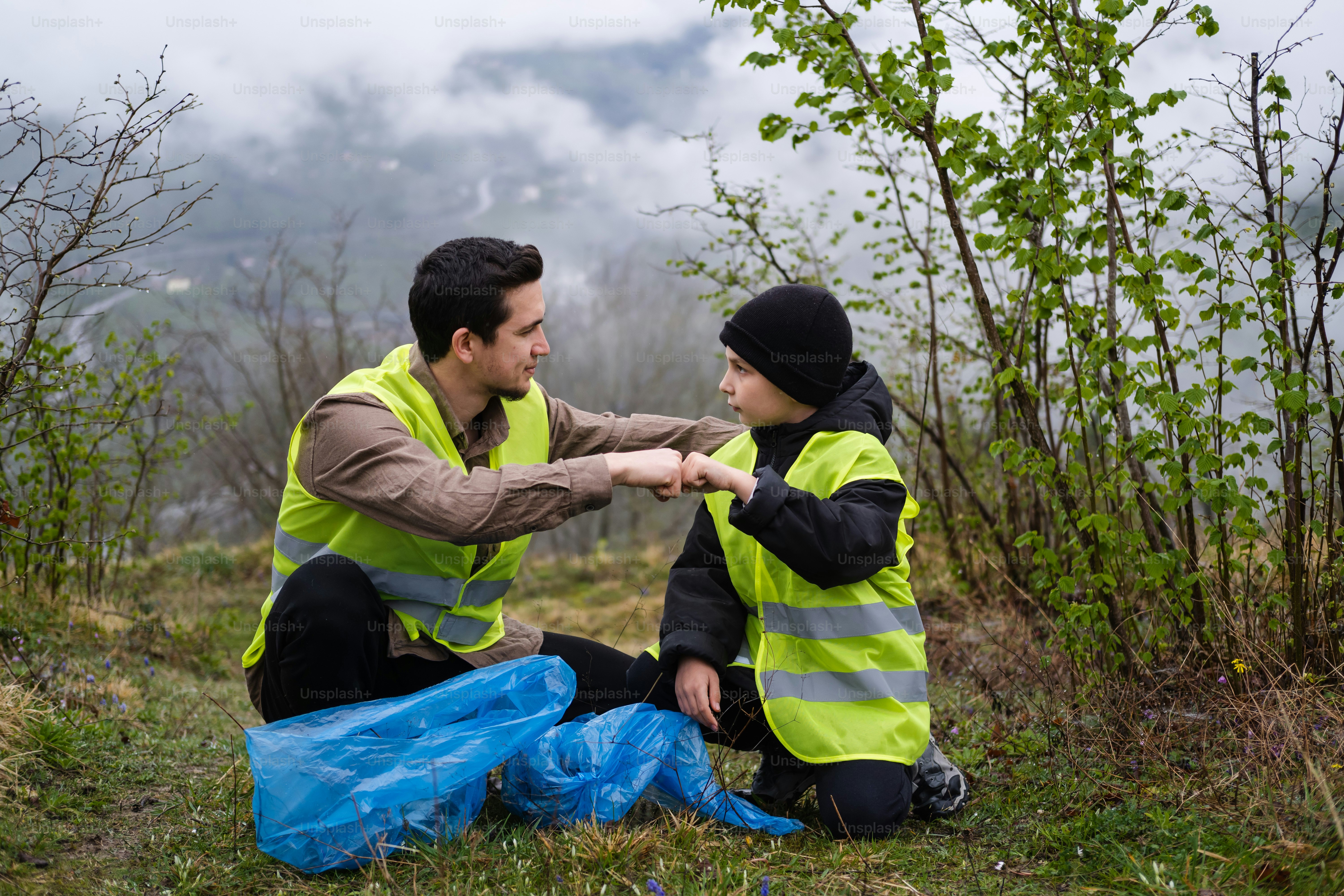 a couple of people sitting on top of a grass covered field