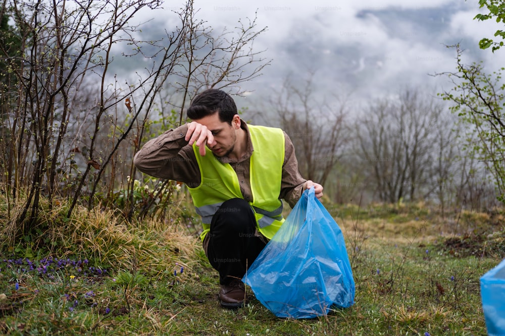 a man in a yellow vest holding a blue bag