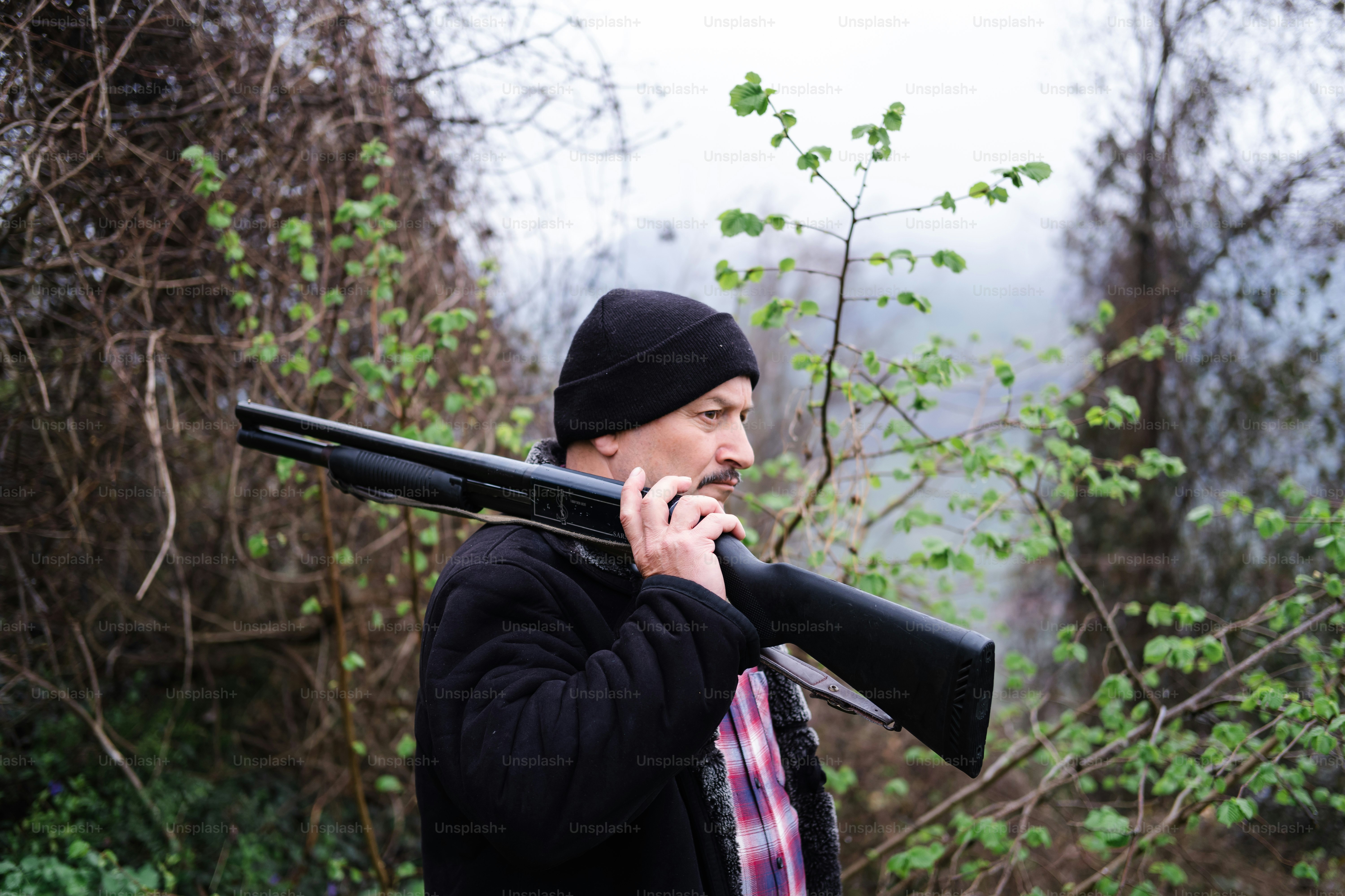 A man holding a rifle and smoking a cigarette photo – Hunting Image on ...
