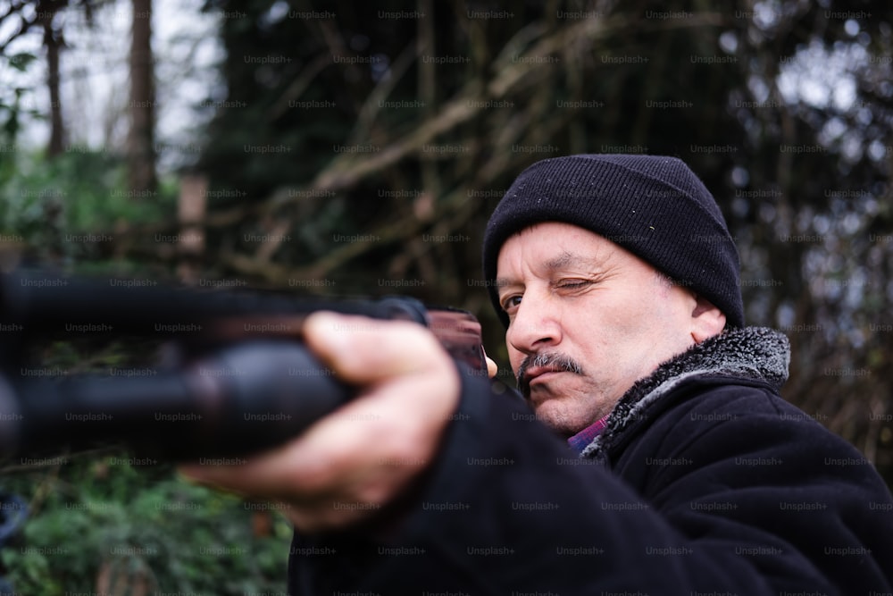 um homem segurando uma arma em sua mão direita
