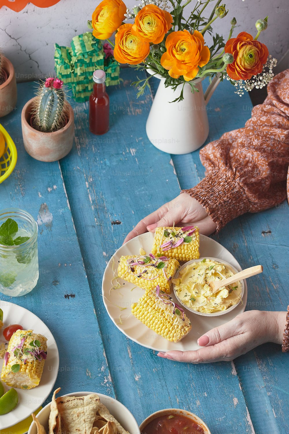 a person holding a plate of food on a table