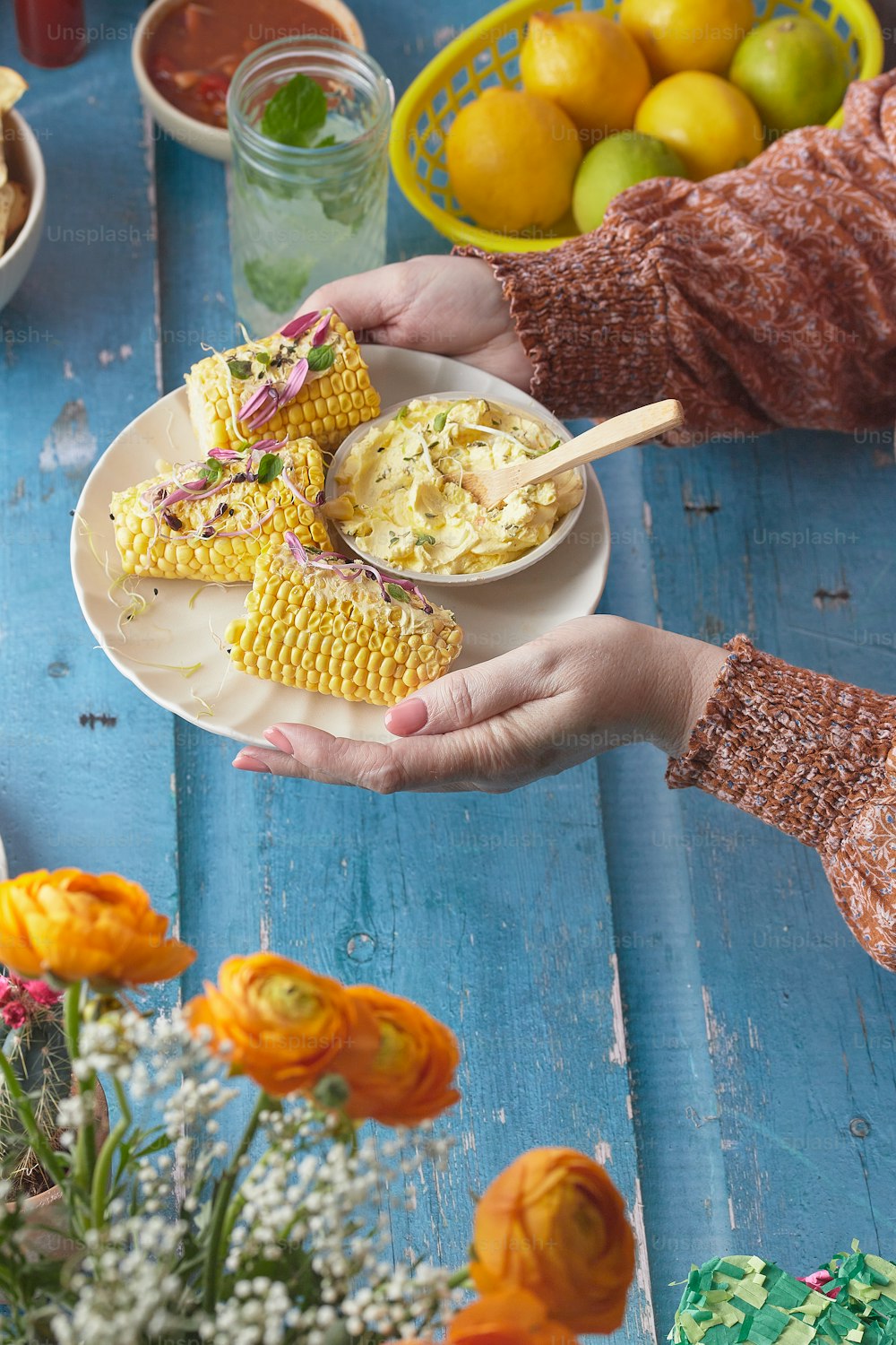 a person holding a plate of food on a table