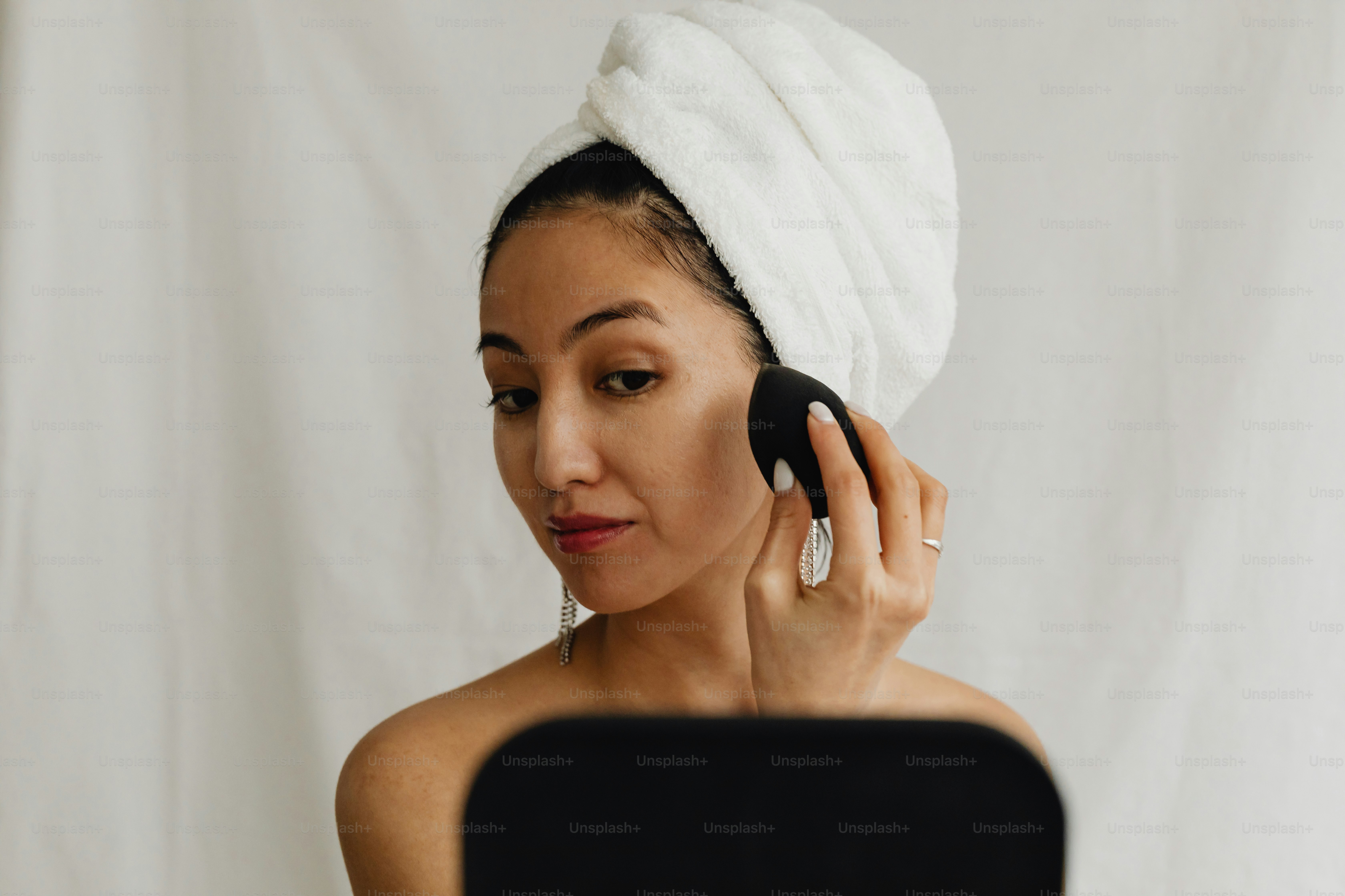 a woman with a towel on her head using a cell phone