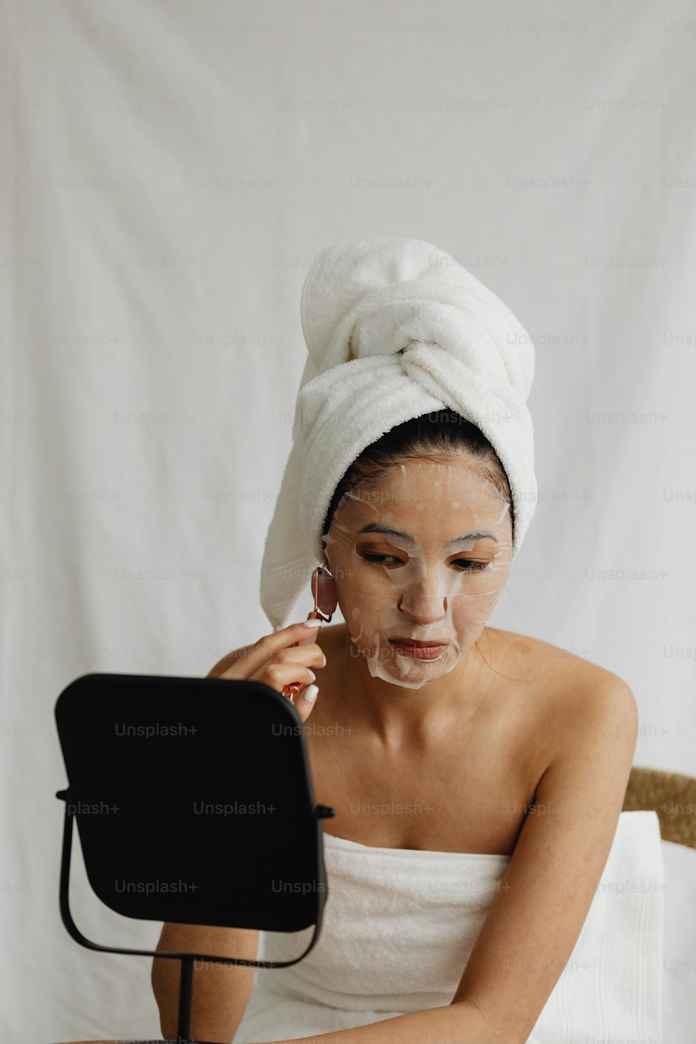 a woman sitting in a chair with a towel on her head