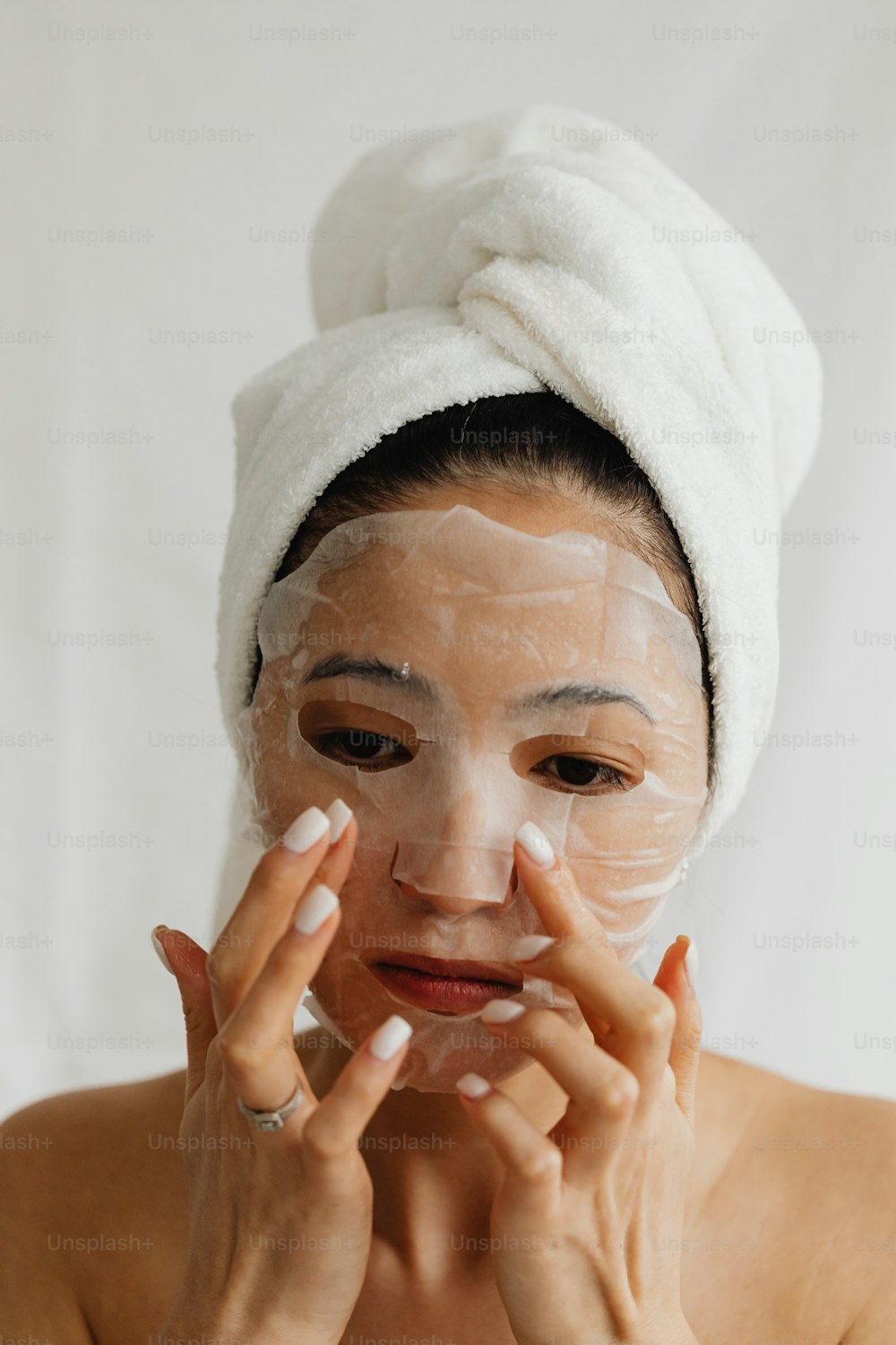 a woman with a towel on her head and a face mask on