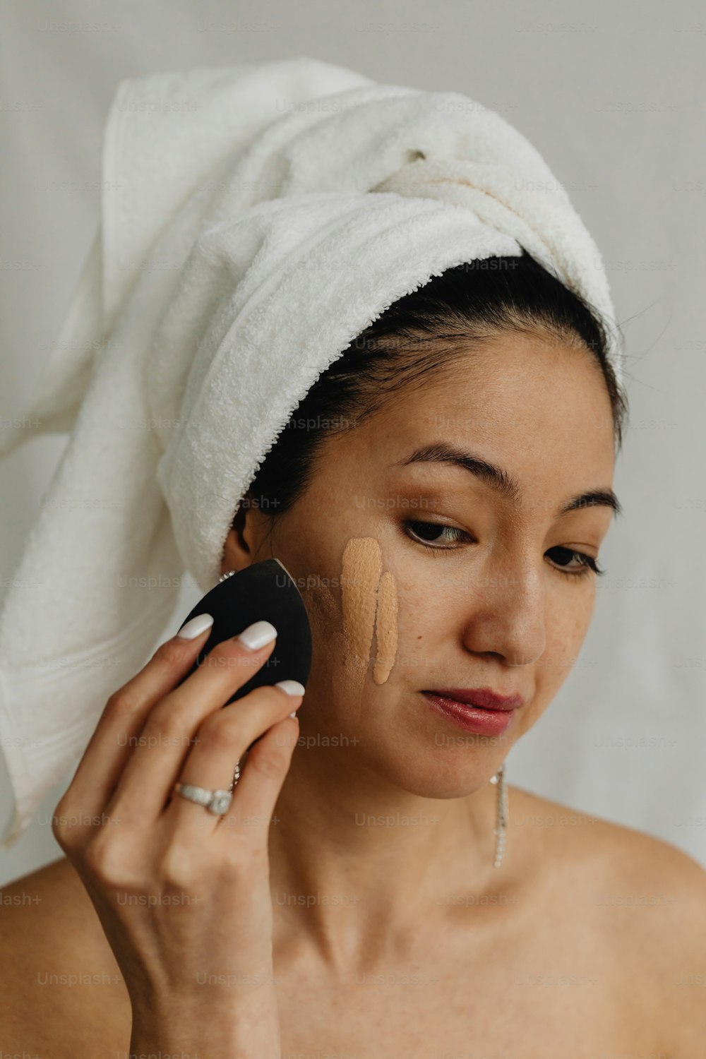 a woman with a towel on her head holding a cell phone to her ear