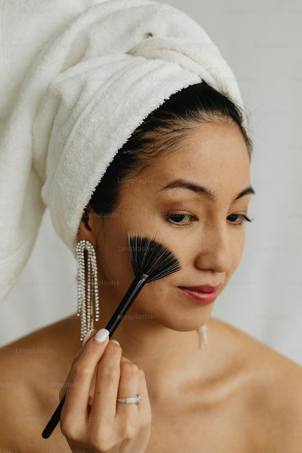 a woman with a towel on her head holding a brush