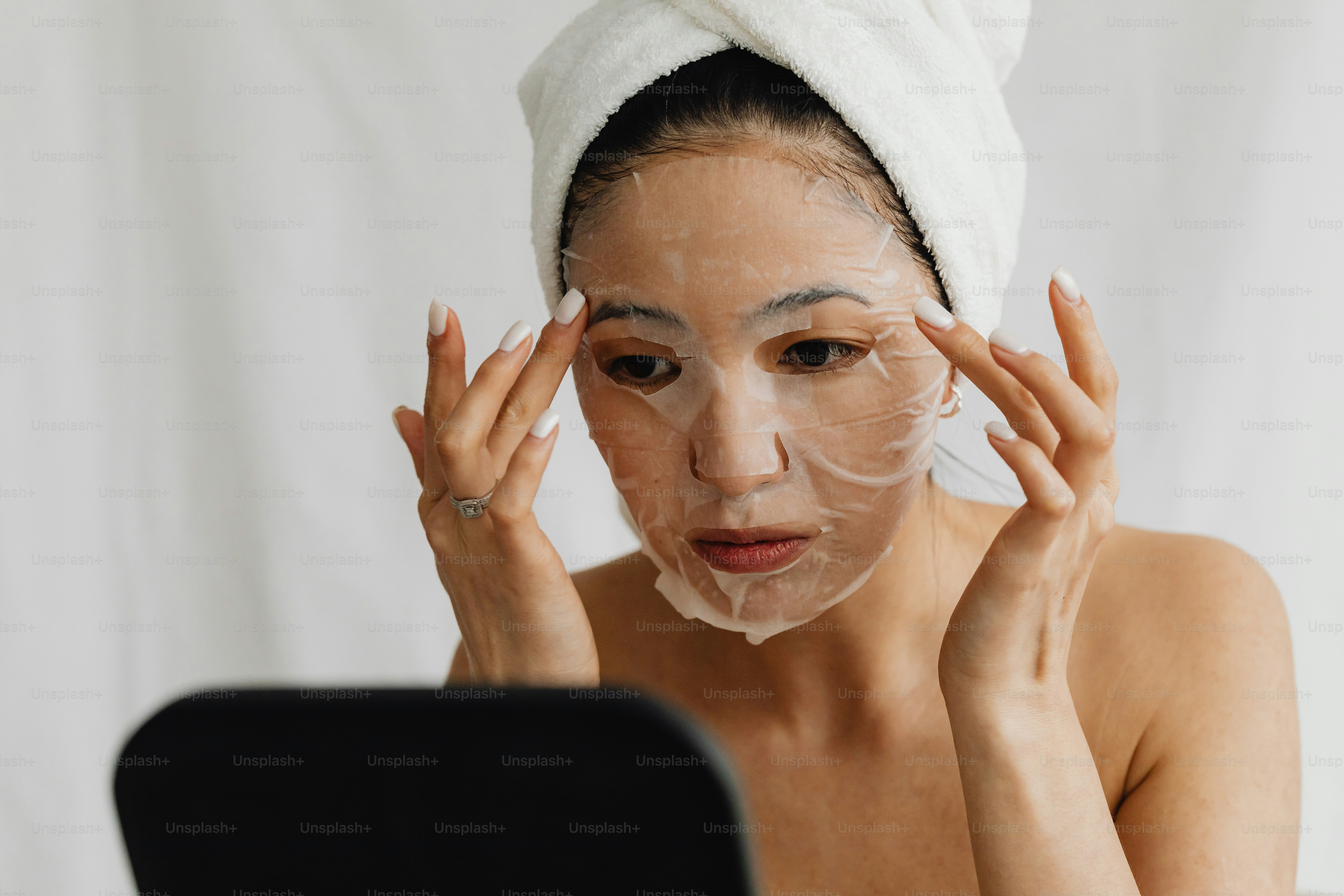 頭にタオルをかぶった女性がノートパソコンを見ている