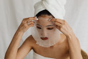a woman with a towel on her head and a sheet on her face
