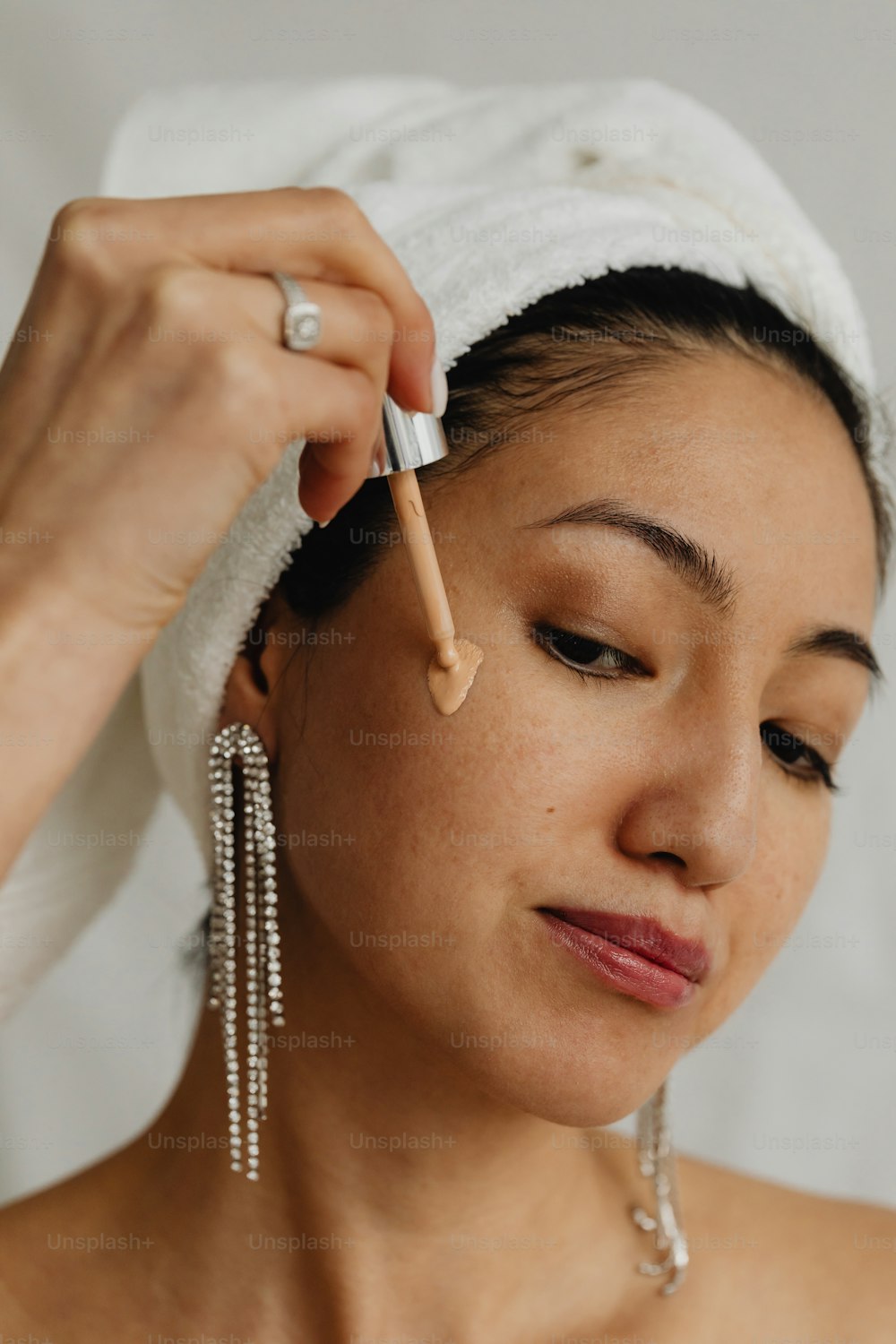 a woman with a towel on her head and a pen in her hand