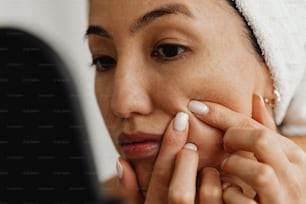 une femme avec une serviette sur la tête mettant ses ongles