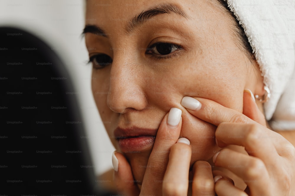 a woman with a towel on her head putting on her nails