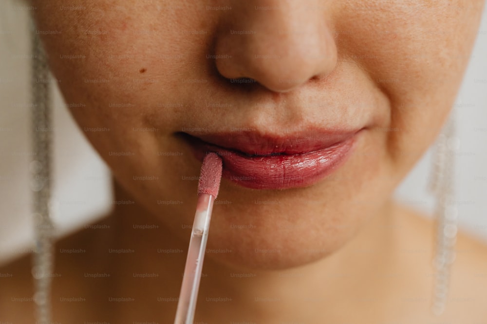 a close up of a person with a lip brush in their mouth