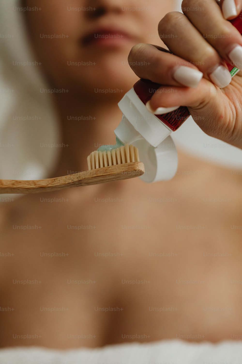 a woman holding a toothbrush in her right hand