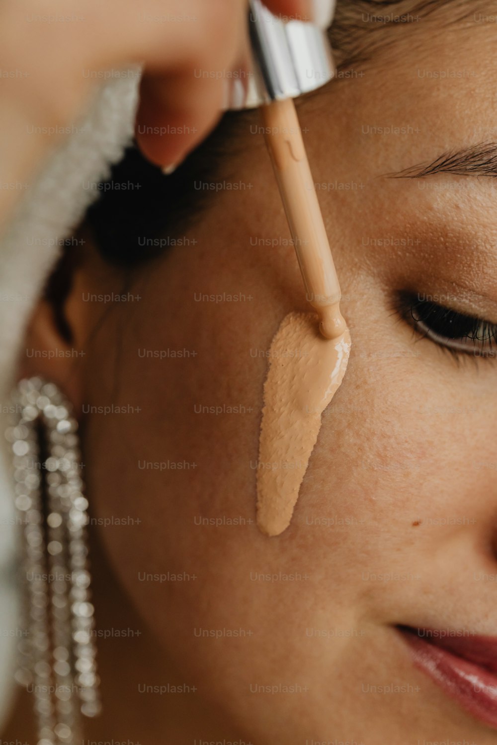 Una mujer maquillándose con un pincel