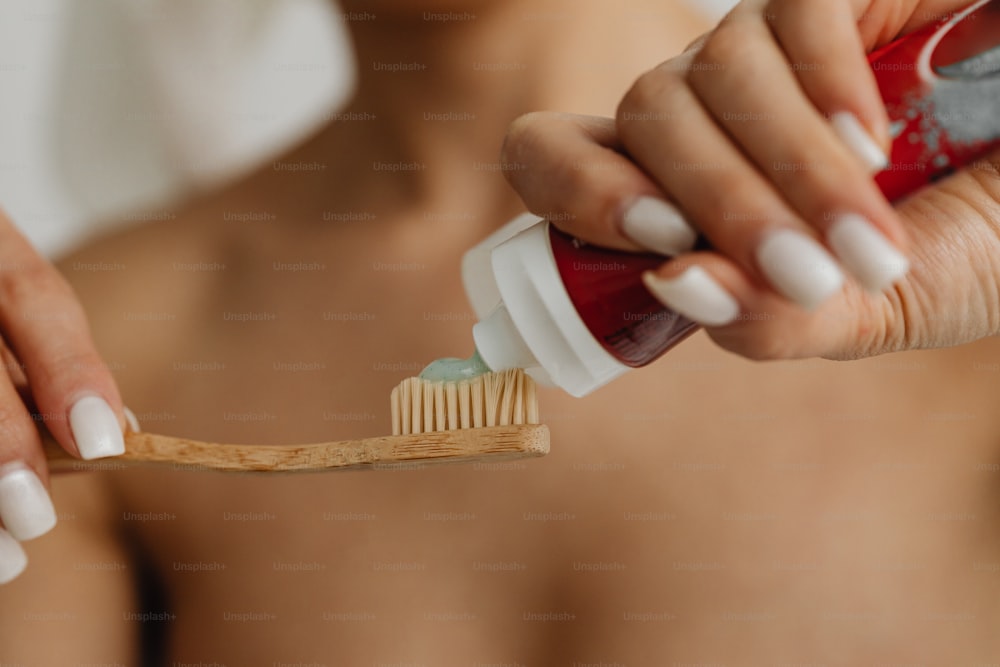 a woman brushing her teeth with a toothbrush