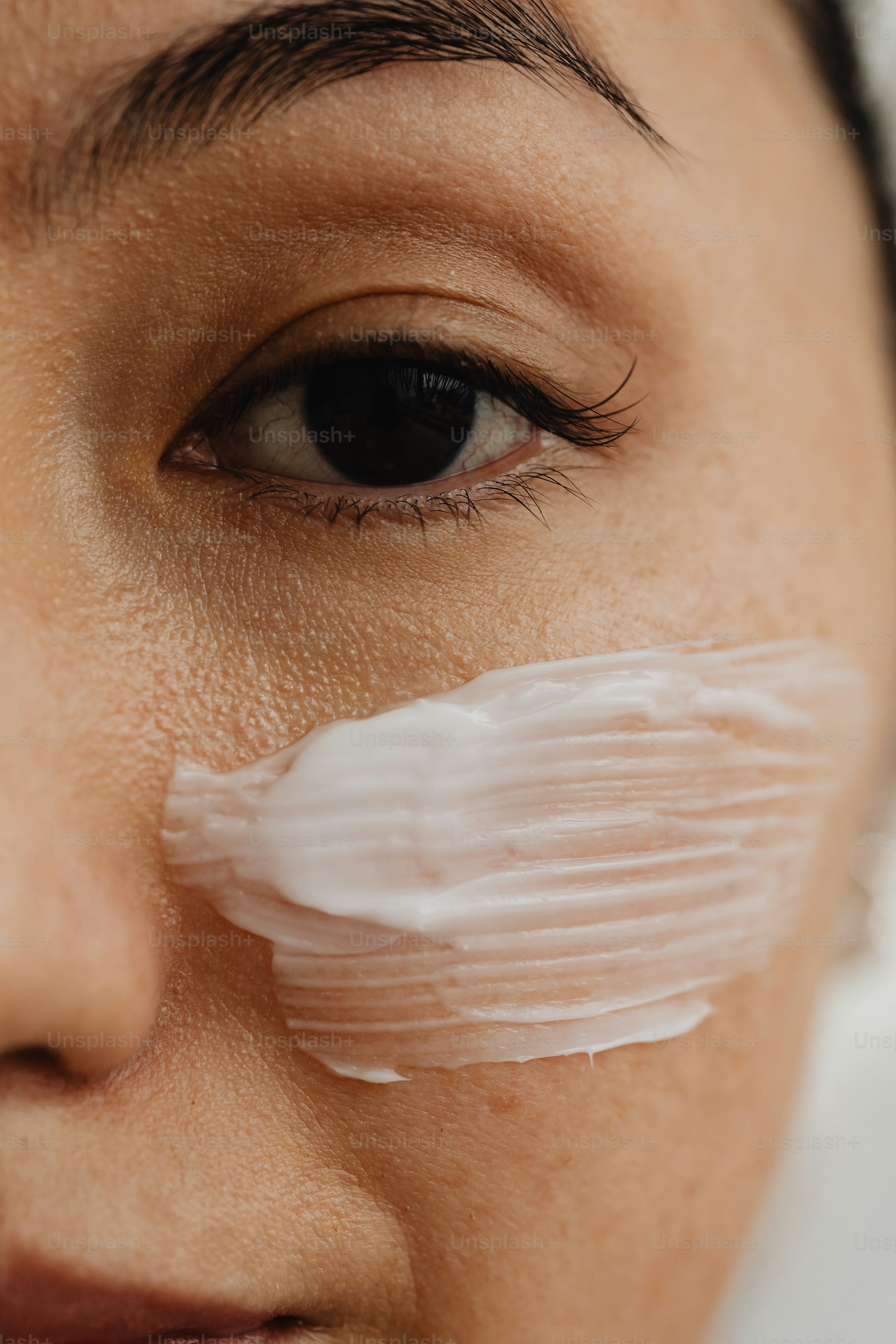 Nahaufnahme einer Frau mit einem Blatt Papier auf dem Auge