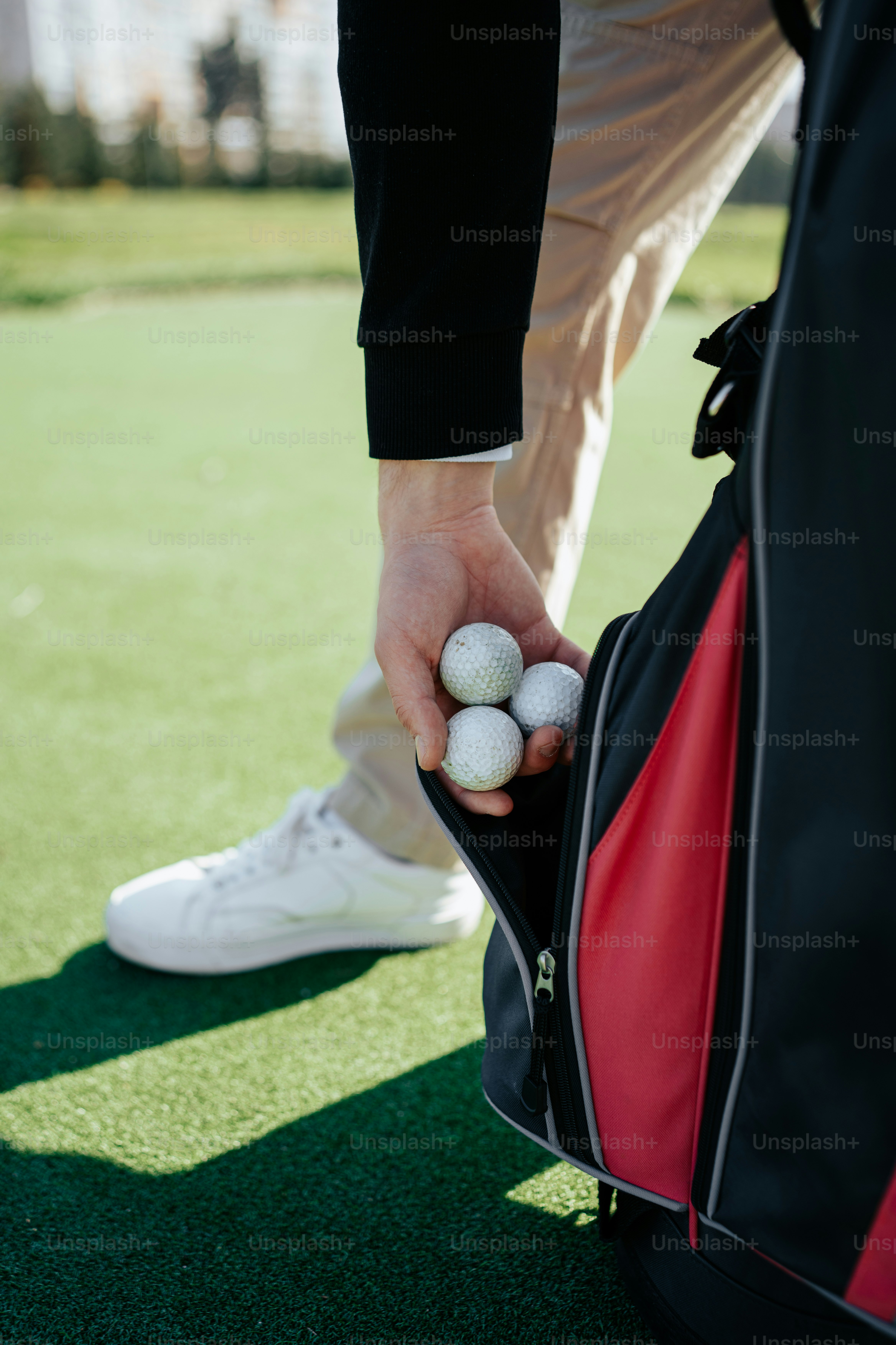 seseorang memegang bola golf di dalam tas