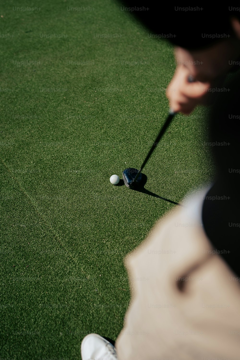 ゴルフクラブでゴルフボールを打つ男