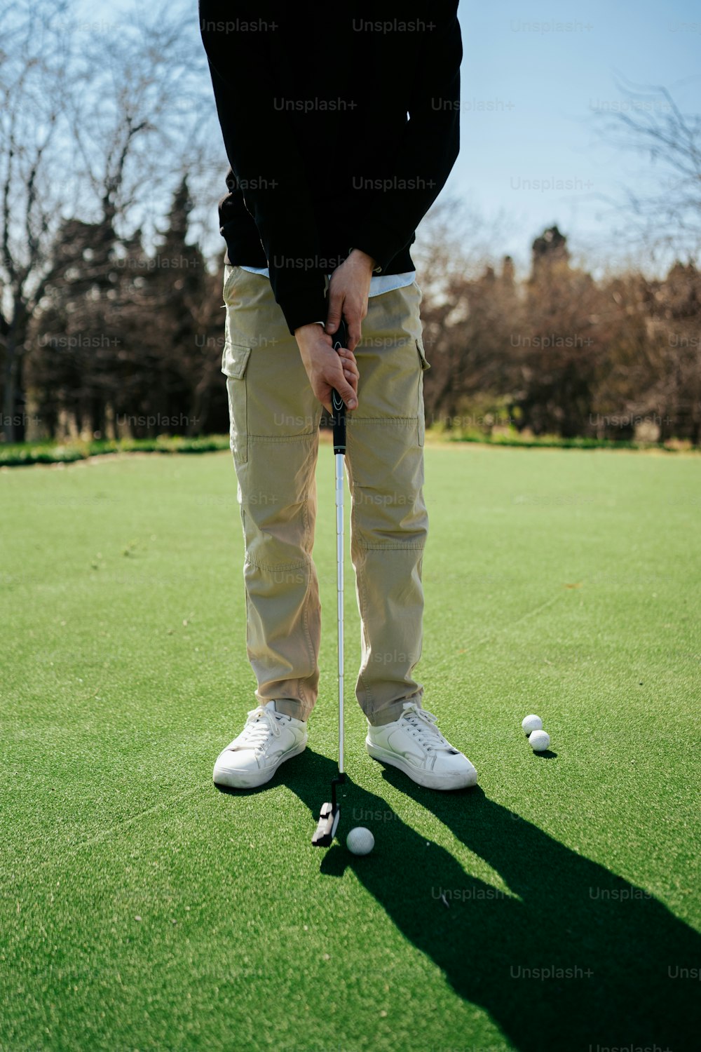 Un uomo in piedi in cima a un campo verde che tiene una mazza da golf