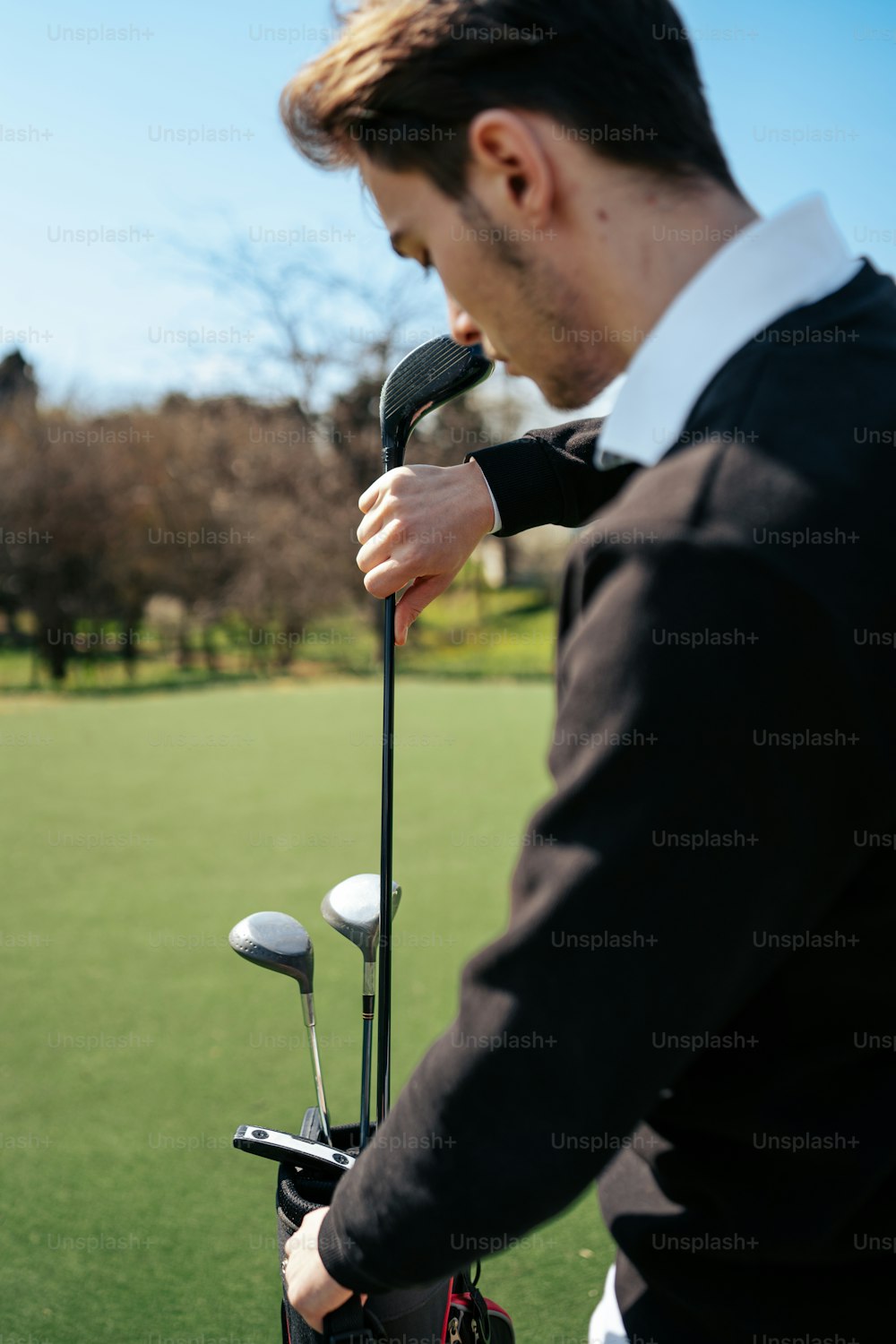 Un hombre sosteniendo un palo de golf en un campo de golf