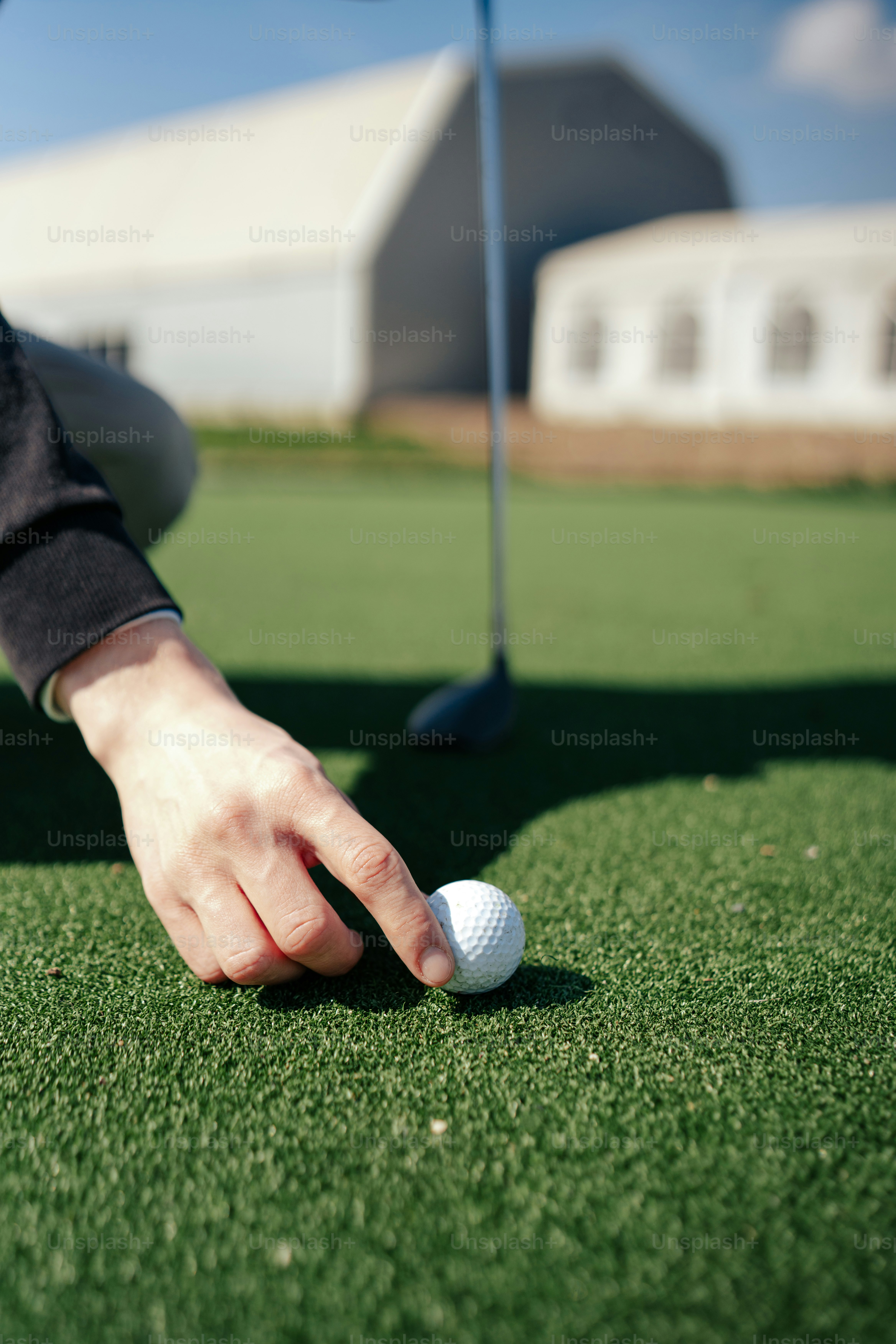 a person putting a golf ball in the hole
