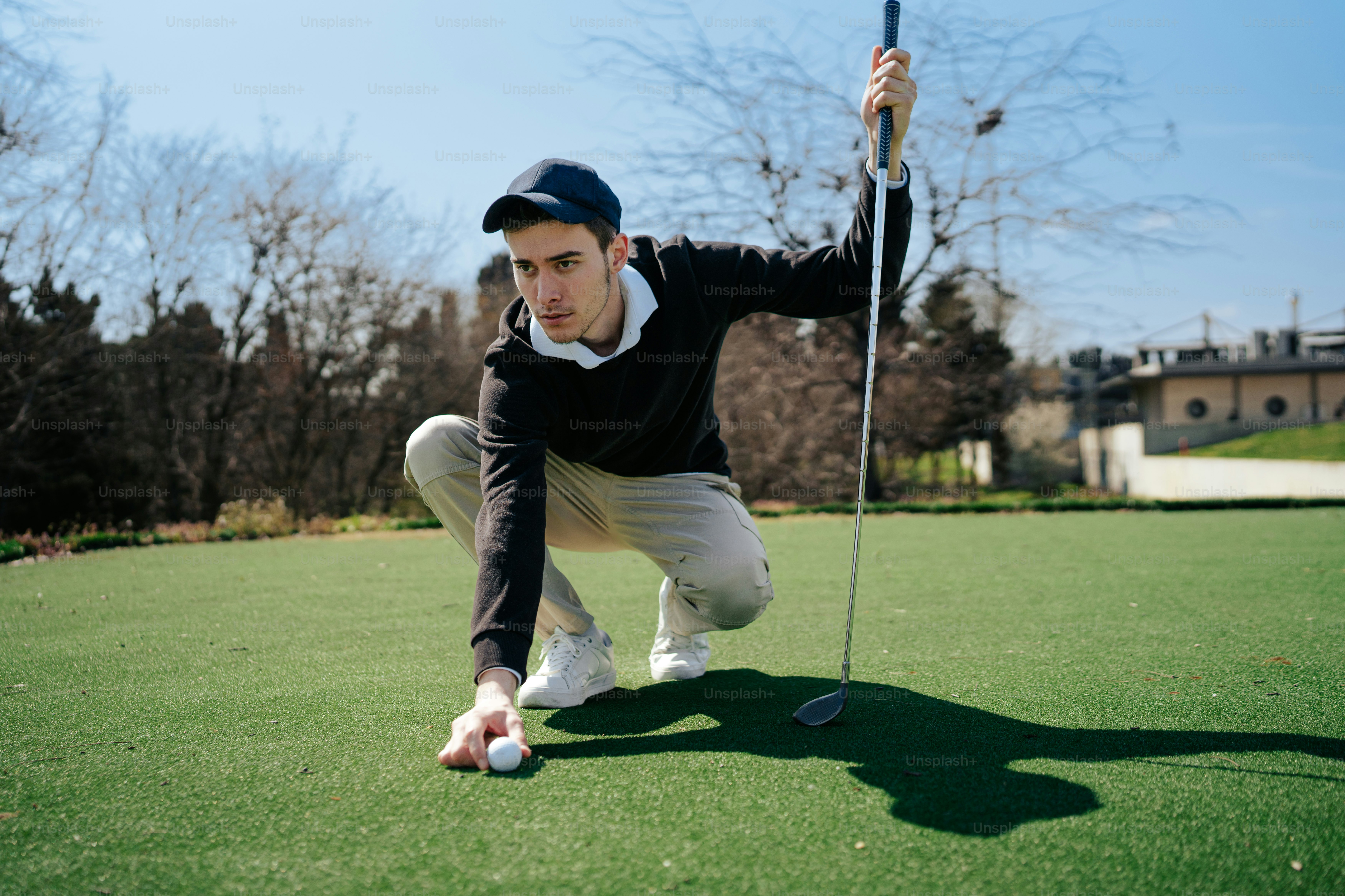 a man kneeling down to pick up a golf ball