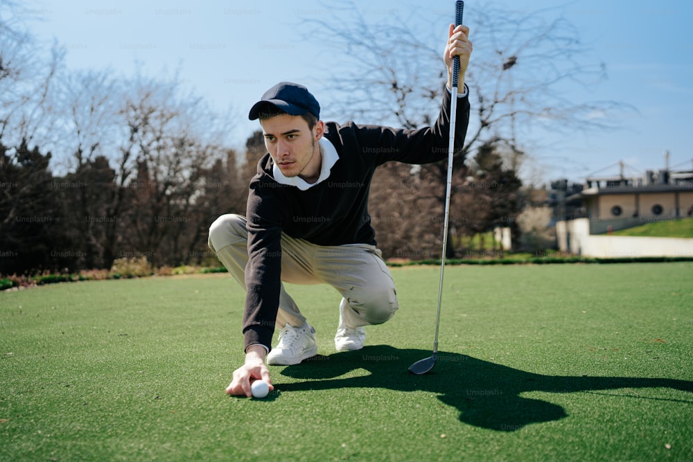 Un hombre arrodillado para recoger una pelota de golf