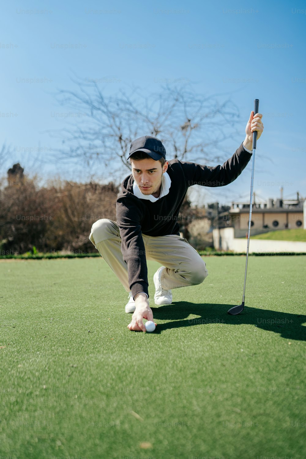 a man kneeling down to pick up a golf ball