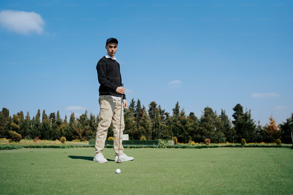 a man standing on top of a green field next to a golf ball