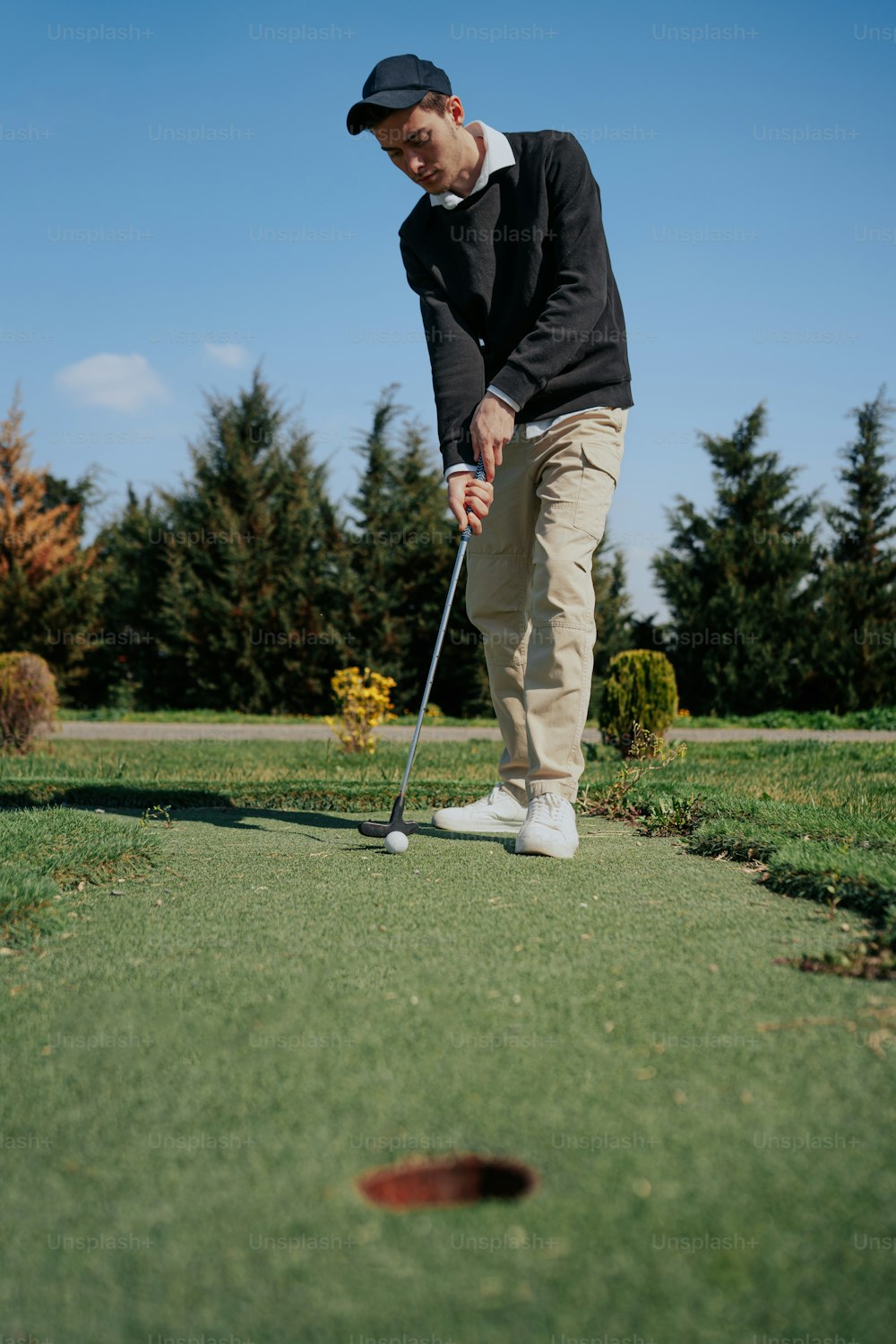 Un hombre está jugando al golf en un campo verde