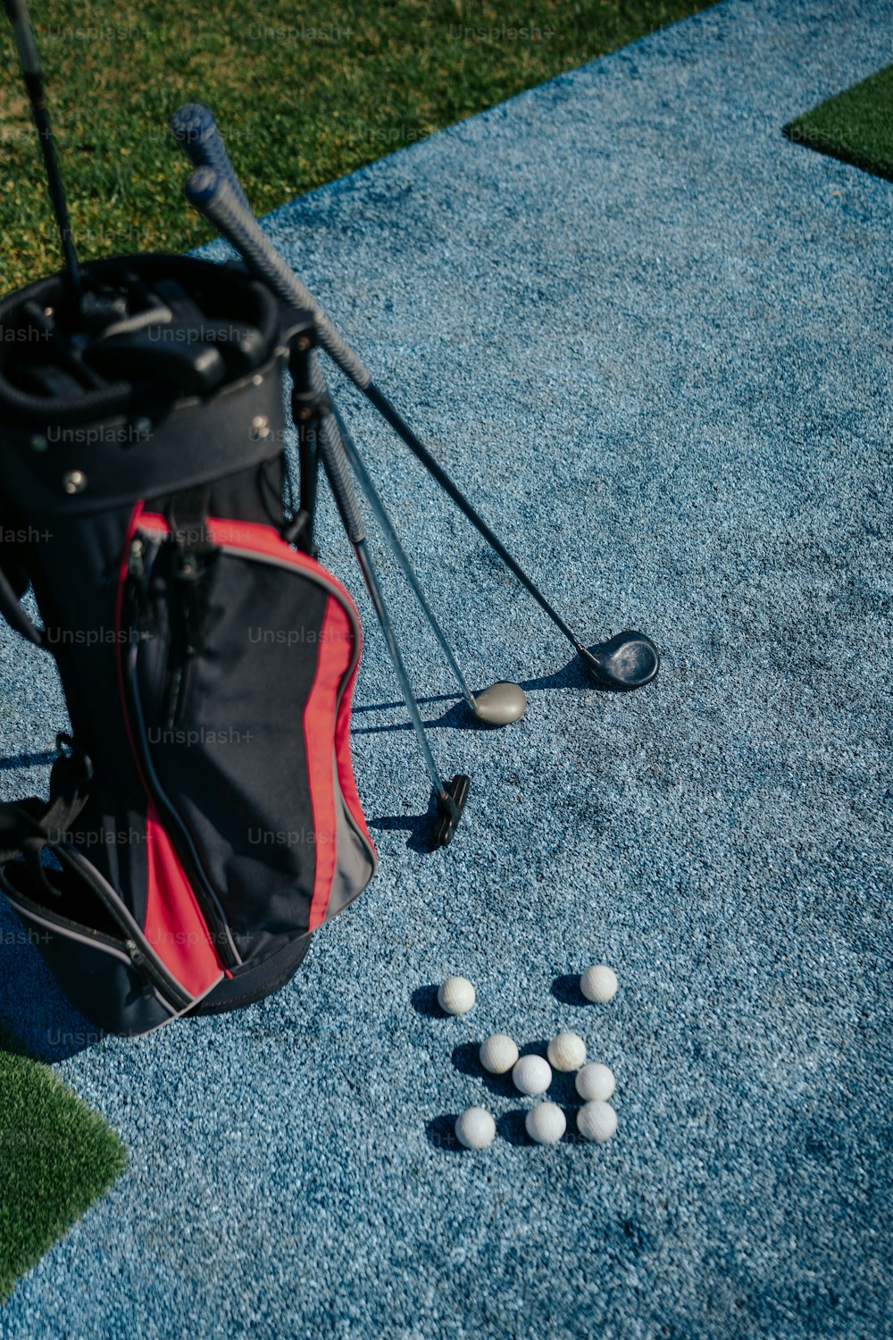 골프 클럽 옆 바닥에 앉아있는 골프 공 가방