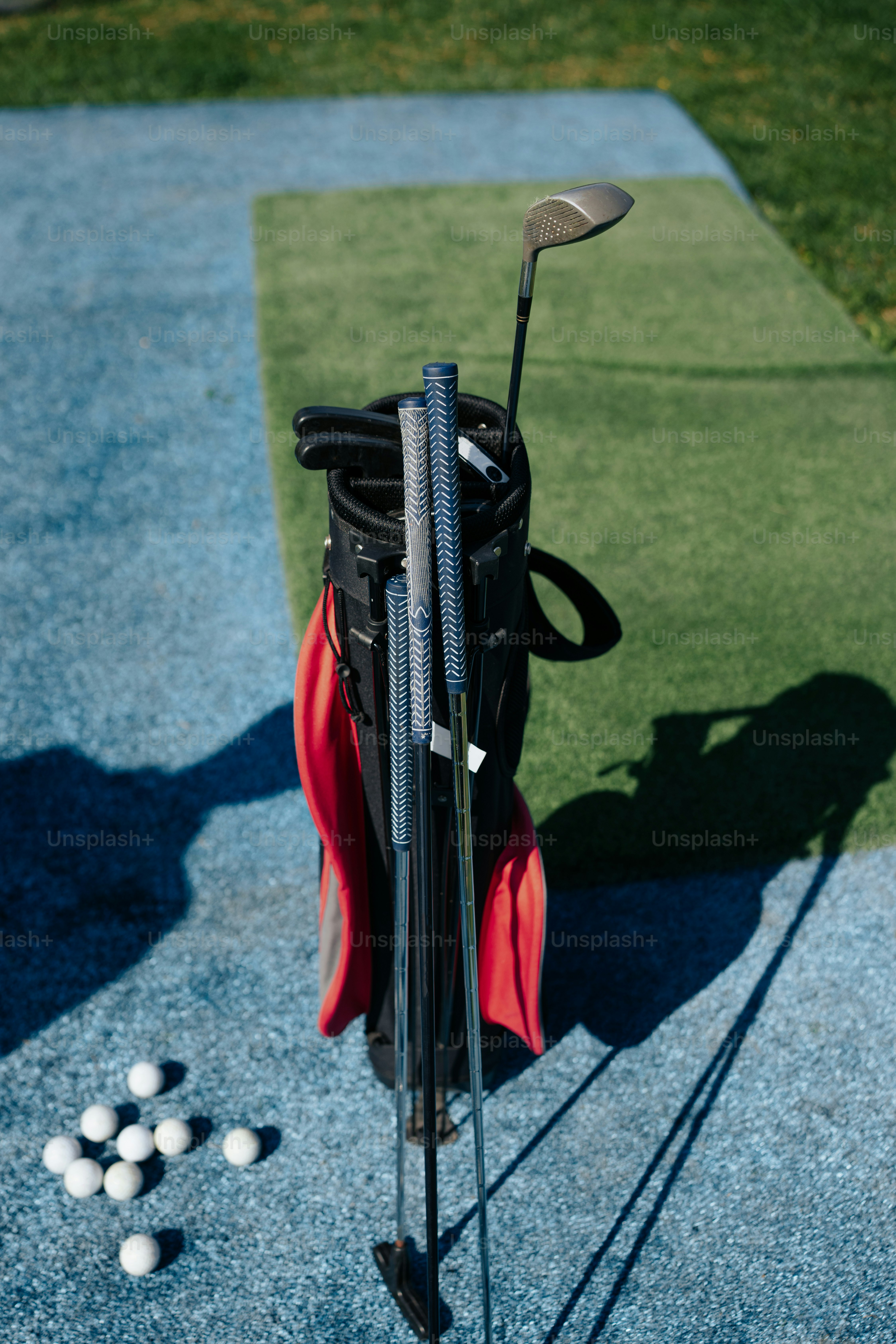 パッティンググリーンの上のゴルフバッグとゴルフボール
