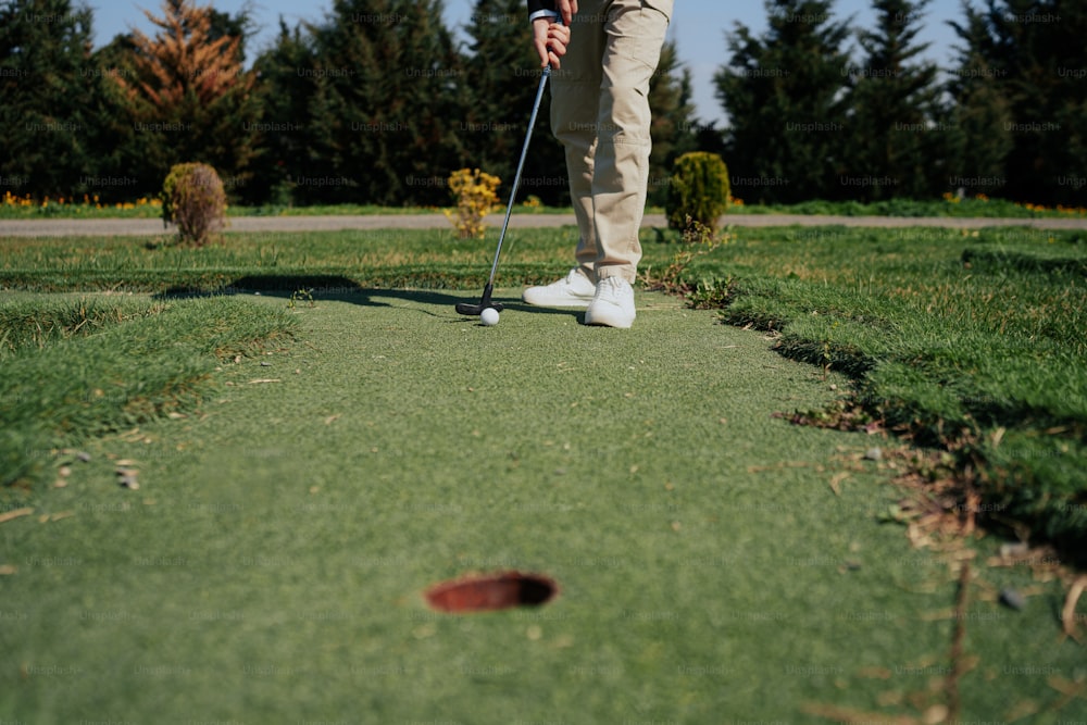 a man is playing golf on a green course