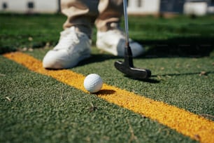 a golf ball sitting on the edge of a yellow line