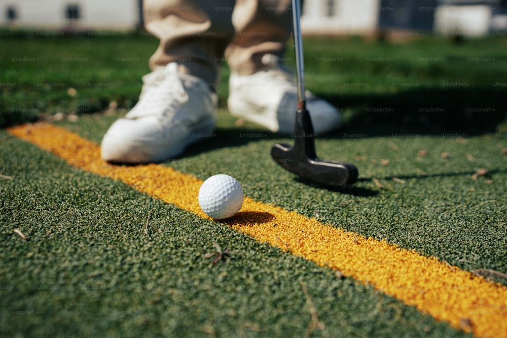 una pallina da golf seduta sul bordo di una linea gialla