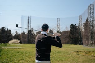 a man in a suit swinging a golf club