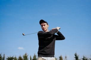 a man swinging a golf club on a sunny day