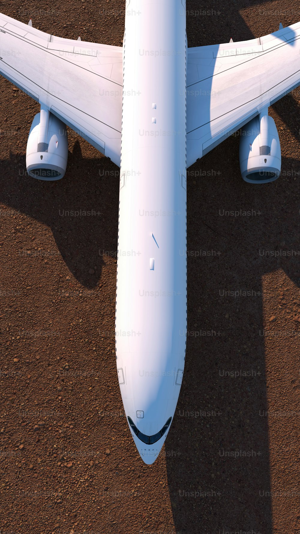 Un gran avión blanco sentado en la parte superior de un campo de tierra