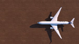 Un avión blanco volando sobre un suelo marrón