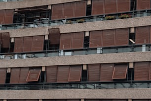 um edifício alto com muitas janelas e persianas de madeira