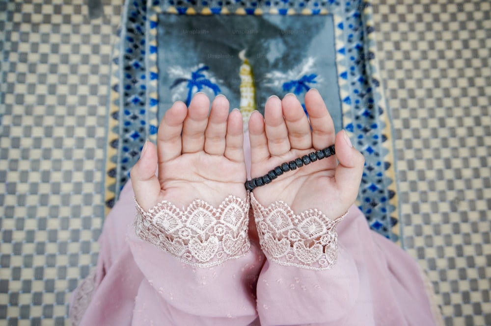 a woman in a pink dress holding her hands together