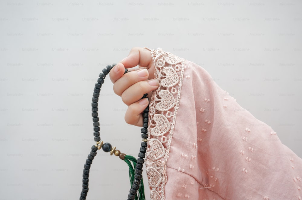 une main de femme tenant un bracelet perlé