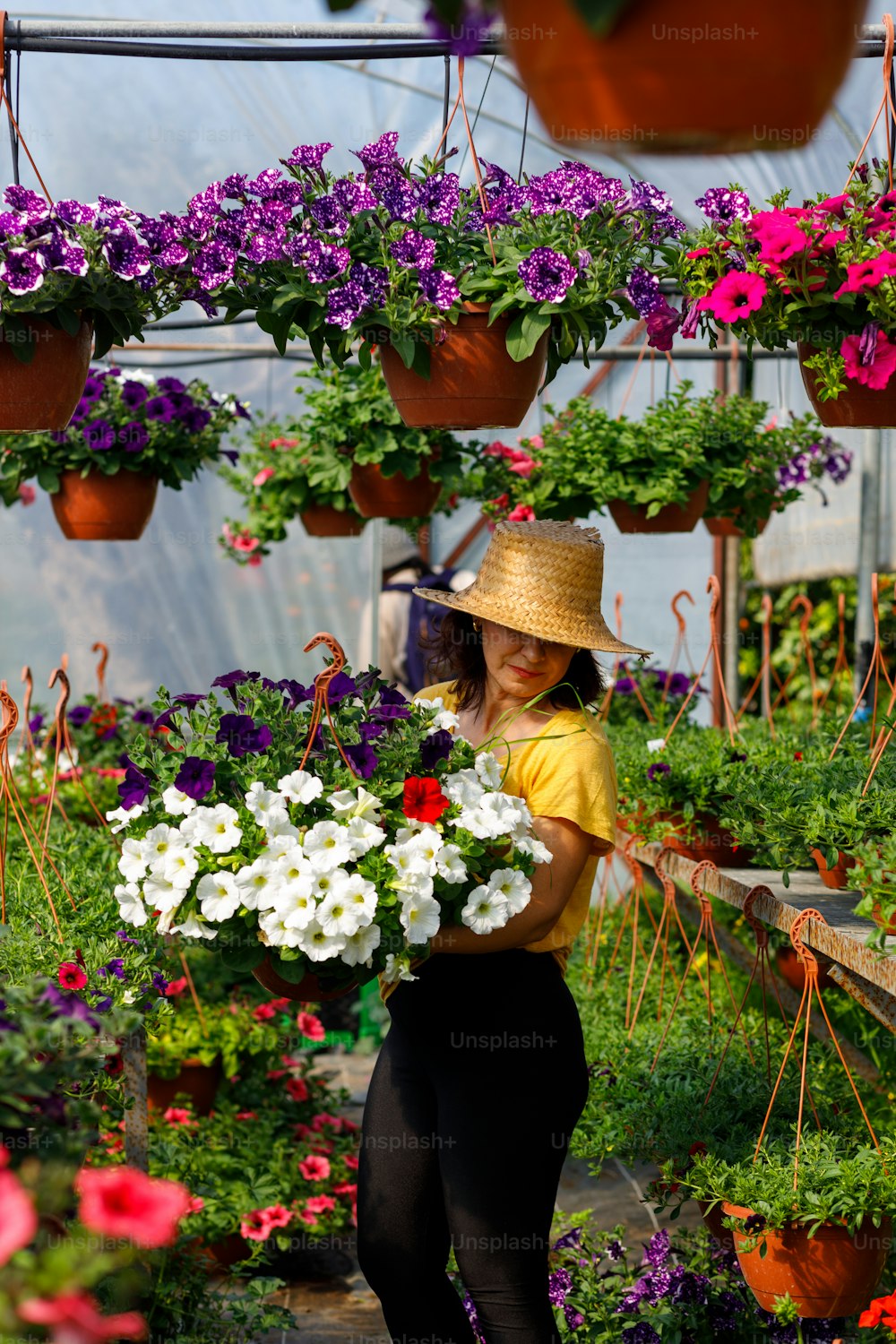 Una mujer sosteniendo un ramo de flores en un invernadero