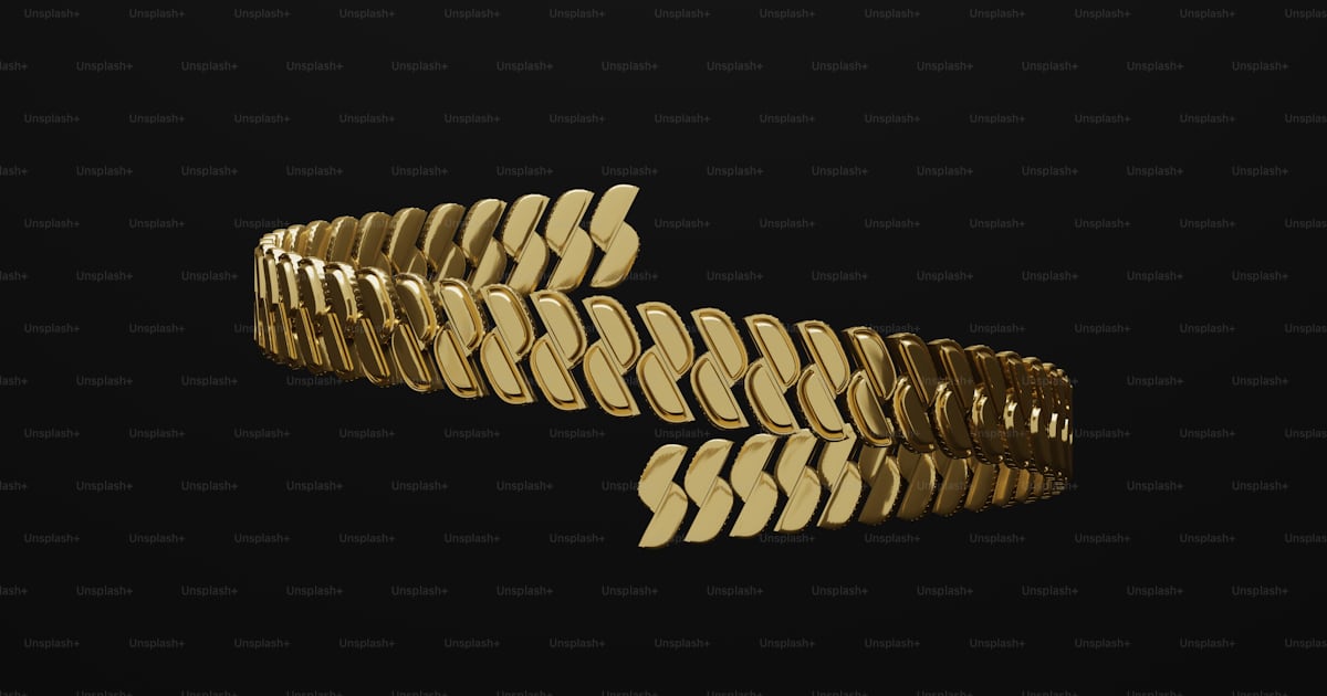 A close up of a gold bracelet on a black background photo – Gold chain