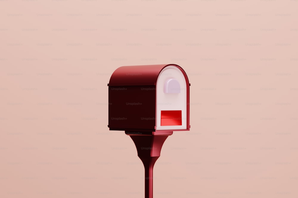 Una cassetta postale rossa e bianca seduta in cima a un palo