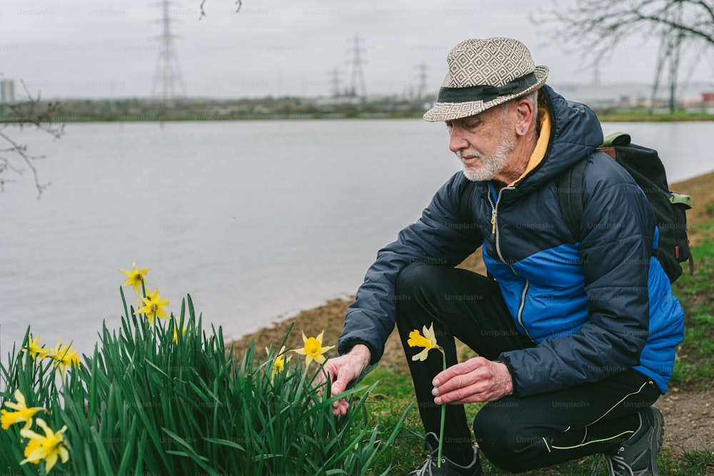 a man kneeling down next to a body of water